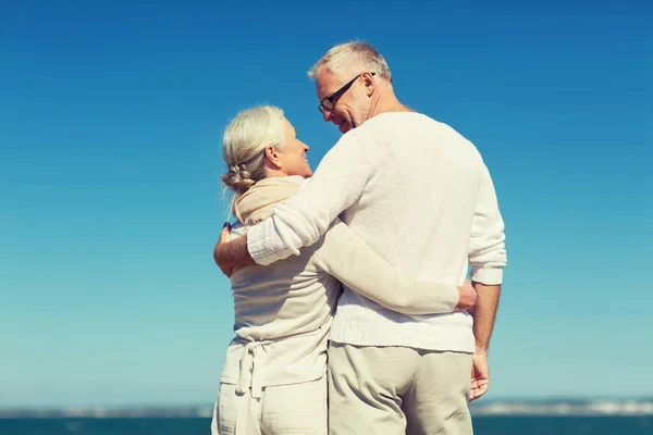 Gelukkige senior paar knuffelen op zomer strand — Stockfoto