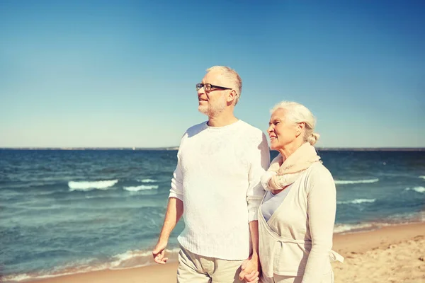 Gelukkige senior paar wandelen langs strand van de zomer — Stockfoto