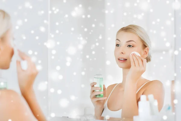 Mujer joven con la cara de lavado de loción en el baño — Foto de Stock