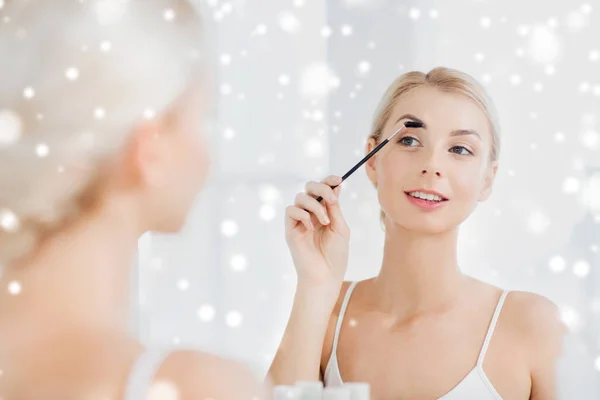 Mujer cepillando cejas con cepillo en el baño — Foto de Stock