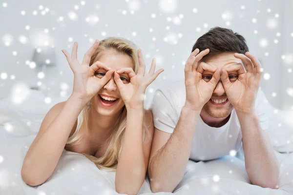 Casal feliz deitado na cama em casa — Fotografia de Stock