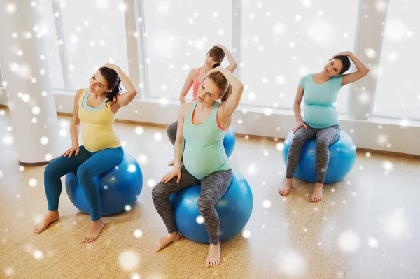 Счастливые беременные женщины с мячами для упражнений в тренажерном зале — стоковое фото