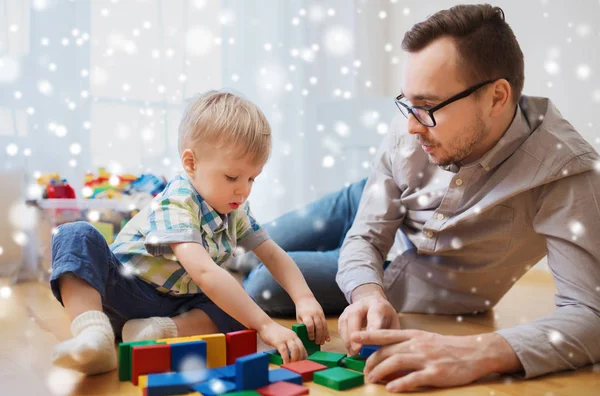 Far och son leker med leksak block hemma — Stockfoto