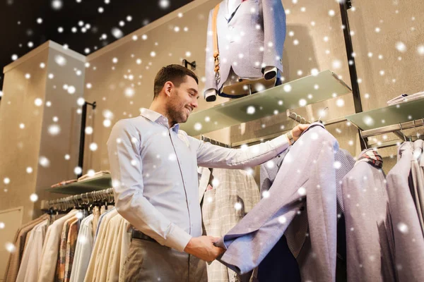 Szczęśliwy młody mężczyzna wybierając ubrania w sklepie odzieżowym — Zdjęcie stockowe