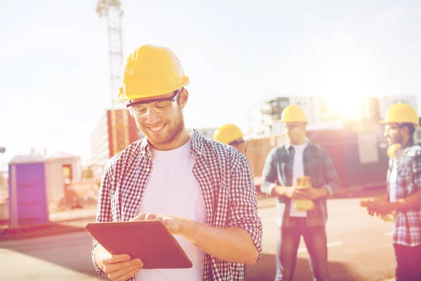 タブレット pc と hardhats で笑みを浮かべてビルダー — ストック写真