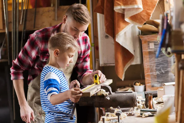 Vater und Sohn mit Lineal messen Holz in Werkstatt — Stockfoto