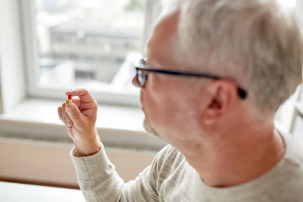 Primer plano de hombre viejo sosteniendo píldora —  Fotos de Stock