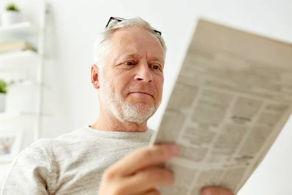 Close up of senior man reading newspaper at home — Stock Photo, Image