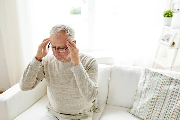Senior man suffering from headache at home — Stock Photo, Image