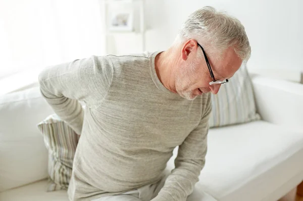 Infeliz anciano que sufre de dolor de espalda en casa —  Fotos de Stock