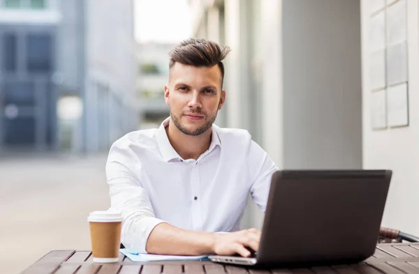 Hombre con portátil y café en la cafetería de la ciudad — Foto de Stock