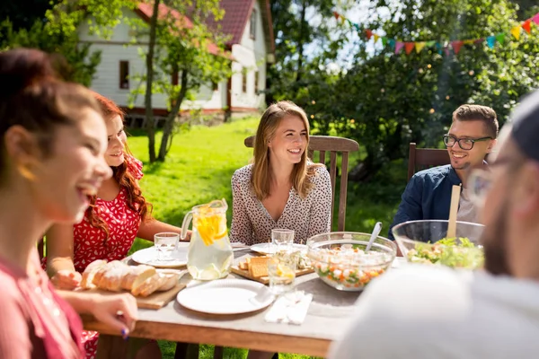 Glückliche Freunde beim Abendessen bei sommerlicher Gartenparty — Stockfoto