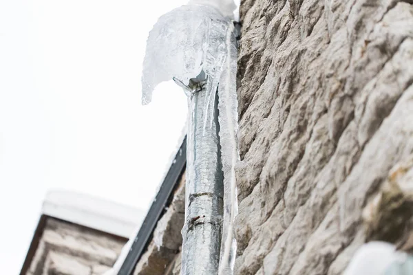 Eiszapfen hängen an Hausabflussrohr — Stockfoto