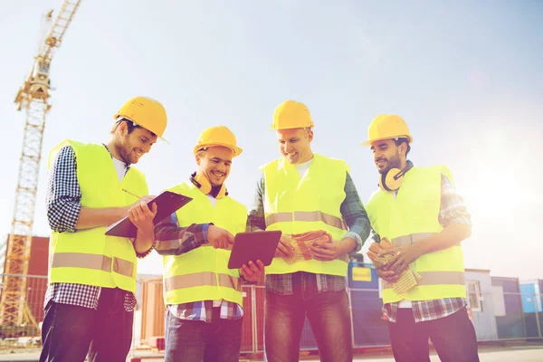 Groupe de constructeurs souriants avec tablette PC à l'extérieur — Photo