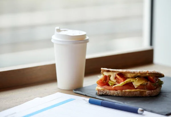 Lososový sendvič panini a šálek nápoje v kavárně — Stock fotografie