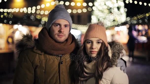 Boldog pár átölelve a karácsonyi vásár — Stock videók
