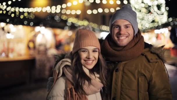 Счастливая пара обнимается на рождественском рынке — стоковое видео