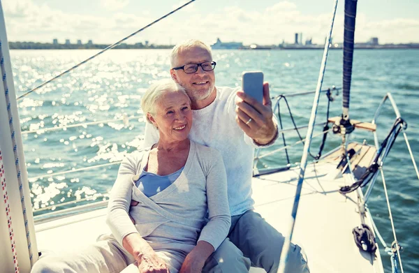 Seniorzy z smartphone przy selfie na jachcie — Zdjęcie stockowe