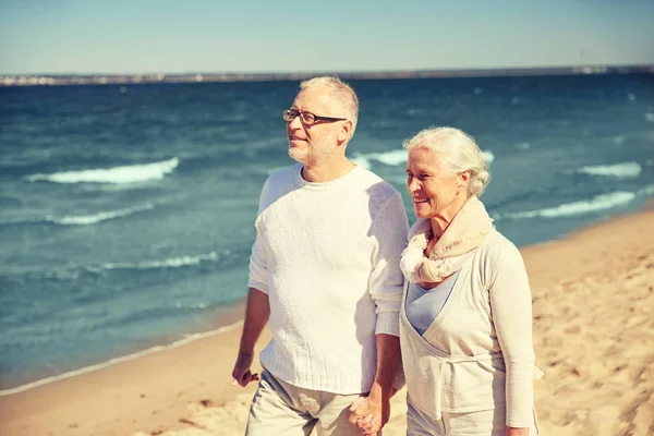 Счастливая пожилая пара, гуляющая по летнему пляжу — стоковое фото