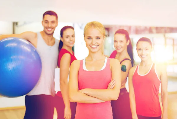Woman standing in front of the group in gym — Stock Photo, Image