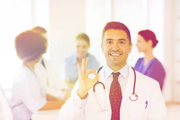 Zufriedener Arzt über Gruppe von Sanitätern im Krankenhaus — Stockfoto
