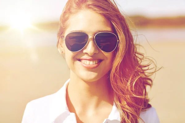 Joven sonriente en gafas de sol en la playa —  Fotos de Stock