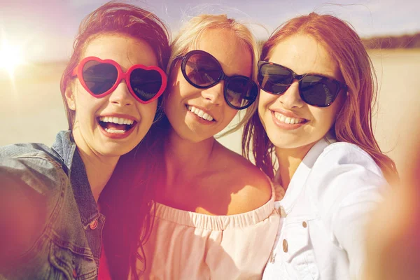 Grupo de mujeres sonrientes tomando selfie en la playa — Foto de Stock