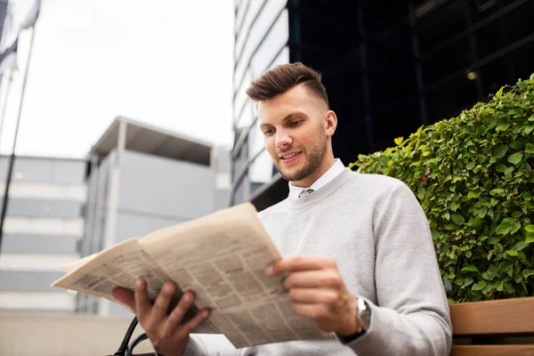 Gülümseyen adam şehir sokak bankta gazete okuma — Stok fotoğraf