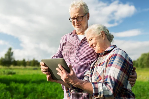 Feliz pareja de ancianos con PC tableta en la granja de verano —  Fotos de Stock