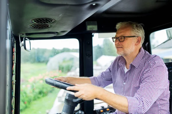 Старший чоловік керує трактором на фермі — стокове фото