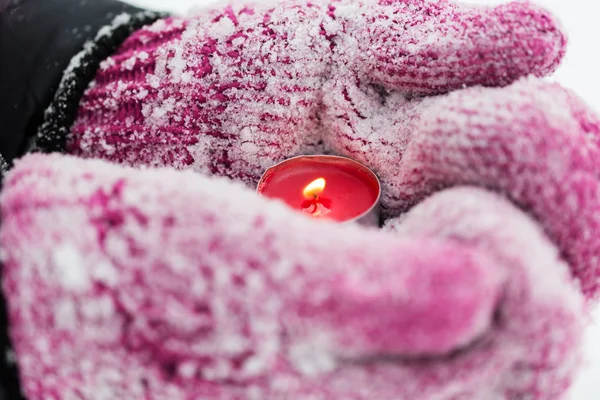 Nahaufnahme von Händen in Winterhandschuhen mit Kerze — Stockfoto