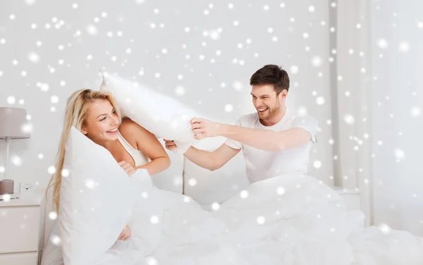 Glückliches Paar bei Kissenschlacht im Bett zu Hause — Stockfoto