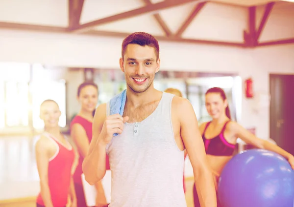 Sonriente hombre de pie frente al grupo en el gimnasio — Foto de Stock