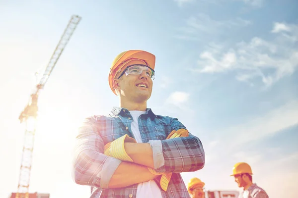 Gruppo di costruttori sorridenti in hardhats all'aperto — Foto Stock