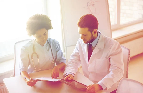 Ärzte mit Tablet-PC und Klemmbrett im Krankenhaus — Stockfoto