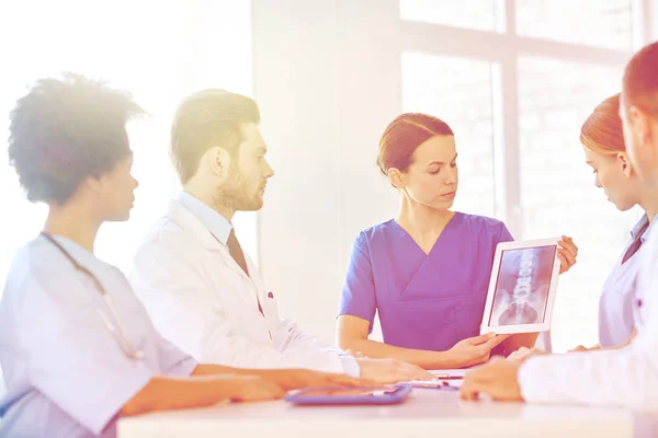 Arztgruppe mit Röntgenbild auf Tablet-PC in Klinik — Stockfoto