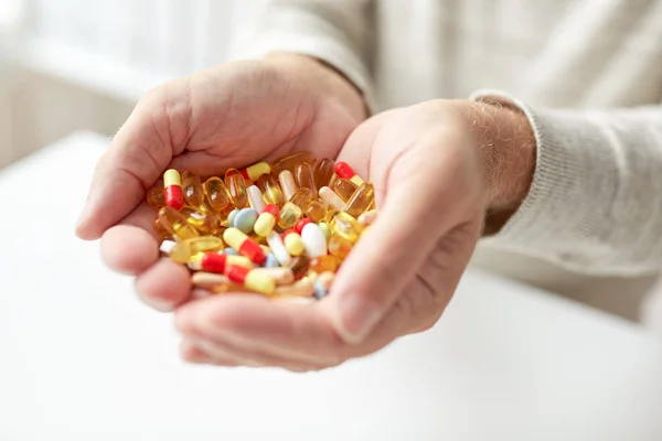 Close up of old man hands holding medicine — Stock Photo, Image