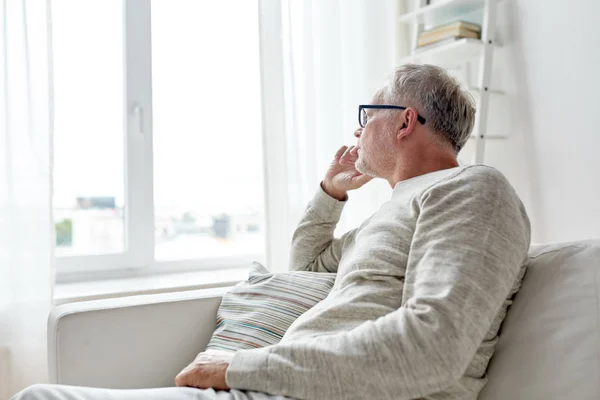 Senior mit Brille denkt zu Hause — Stockfoto