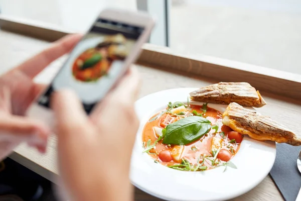 Manos con gazpacho sopa foto en el teléfono inteligente — Foto de Stock