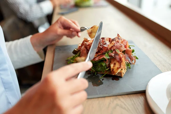 Donna che mangia insalata di prosciutto al ristorante — Foto Stock