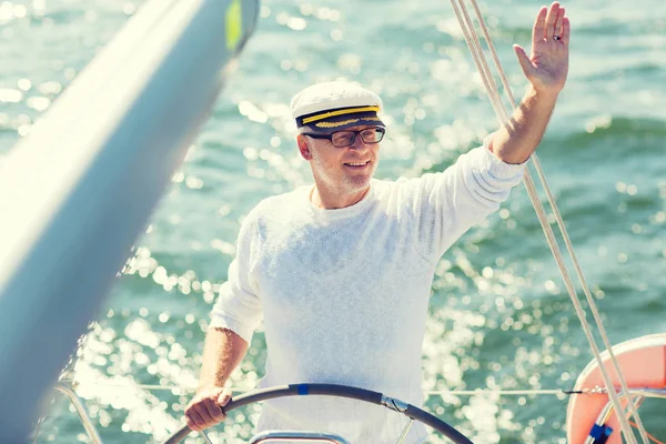 Starszy człowiek w ster na łodzi lub jachtu żeglarstwo w morze — Zdjęcie stockowe