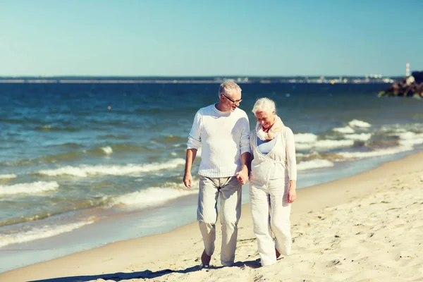 Feliz casal sênior de mãos dadas na praia de verão — Fotografia de Stock