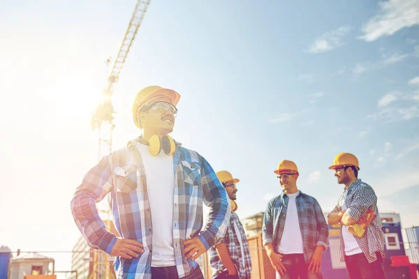 Groupe de constructeurs souriants en hardhats à l'extérieur — Photo