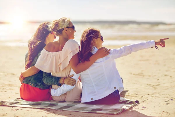 Группа улыбающихся женщин в солнечных очках на пляже — стоковое фото