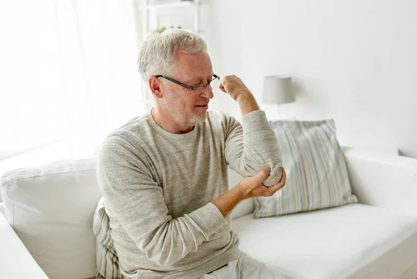 Unhappy senior man suffering elbow pain at home — Stock Photo, Image