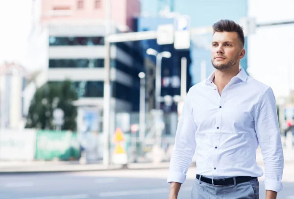 Jonge man wandelen langs stad straat — Stockfoto