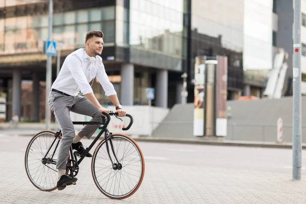 Muž se sluchátky jezdit kole na městské ulici — Stock fotografie
