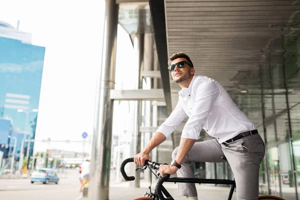 Человек с велосипедом и наушниками на городской улице — стоковое фото