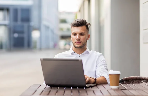 Uomo con computer portatile e caffè al caffè della città — Foto Stock