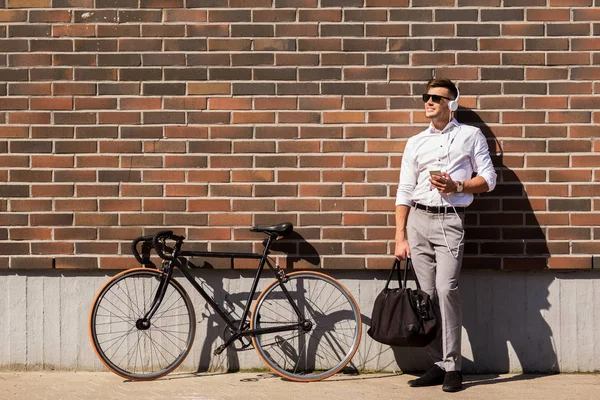 ヘッドフォン、スマート フォンと自転車を持つ男 — ストック写真